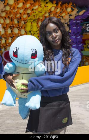 Portrait of a teenage worker in front of a game arcade on the boardwalk at Coney Island, Brooklyn, New York. Stock Photo