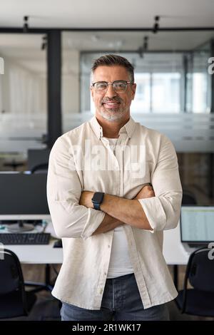 Vertical portrait of senior business man with crossed arms smile at camera Stock Photo