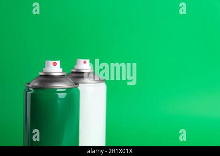 Two cans of spray paints on green background. Space for text Stock Photo