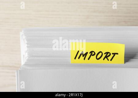 Note with word Import in documentation on white wooden table, closeup Stock Photo