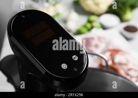 Sous vide cooker in pot on table, closeup. Thermal immersion circulator Stock Photo