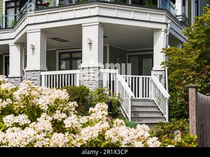 Entrance to a home through a beautiful garden with colorful flowers. Plants and flowers leading to entrance of a townhouse. Front of a house with Gard Stock Photo