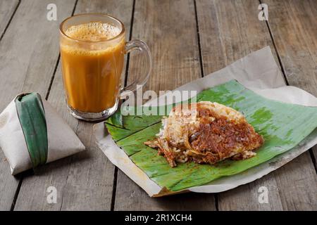 Hot drink Teh Tarik with coconut rice Nasi Lemak Bungkus is a popular breakfast in Malaysia Stock Photo