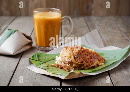 Asian cuisine coconut rice Nasi Lemak Bungkus and hot drink Teh Tarik is a popular breakfast in Malaysia Stock Photo