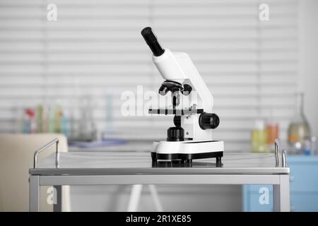 Modern medical microscope on metal table in laboratory Stock Photo