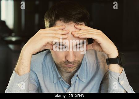 Adult handsome man in shirt standing over black background feeling confuse and wonder about question. studio portrait headshot. Uncertain with doubt, Stock Photo