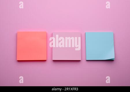 Paper notes on pale pink background, flat lay Stock Photo