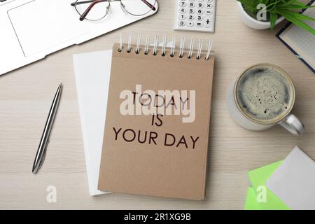 Phrase Today is Your Day in notebook, office stationery and cup of coffee on wooden desk, flat lay Stock Photo
