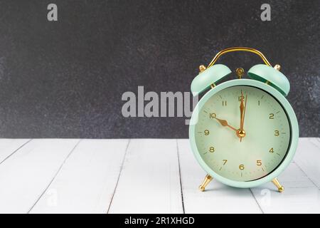 vintage retro alarm clock ten time o'clock on table wood with dark background. Stock Photo