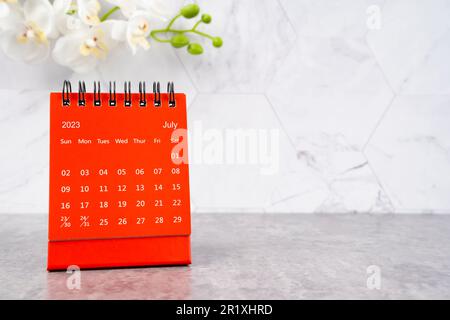 Red calendar July 2023. Desk calendar for year 2023 and white orchid. Stock Photo