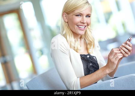 Receiving great news. Portrait of an attractive young businesswoman sending a text message. Stock Photo