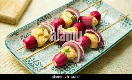 Skewers with wild rabbit meat, onion and tomatoes. Stock Photo