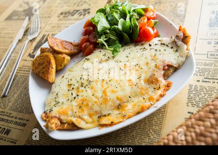 Argentine milanesa with cheese. The milanesa is a fillet, usually beef, that is cooked fried or baked. Stock Photo