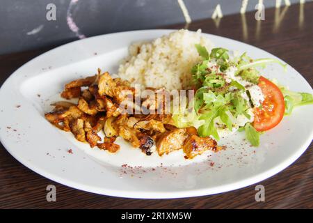 Braised chicken with vegetables and some rice and salad. Stock Photo