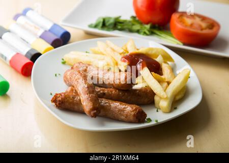 Fried pork sausages with some fries. Stock Photo