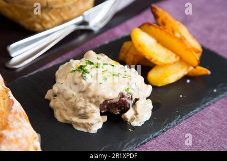 Beef tenderloin served with vegetables and white sauce. Stock Photo