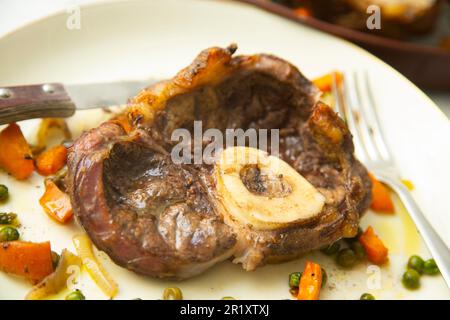 Baked beef ossobuco with vegetables. Stock Photo