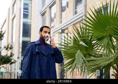 Muslim businessman talking on mobile phone. Arab businessman talking on mobile phone Stock Photo