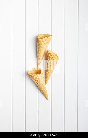 Empty wafer cone. Sweet ice cream cornet on the kitchen table. Top view. Stock Photo