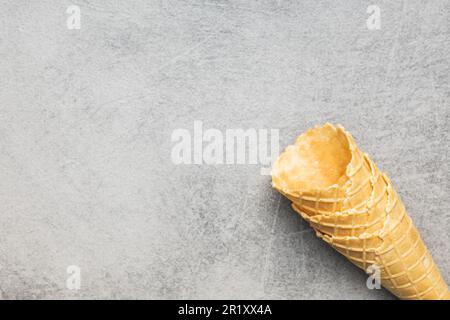 Empty wafer cone. Sweet ice cream cornet on the kitchen table. Top view. Stock Photo