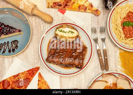 A set of delicious dishes starring a roasted leg and ribs with barbecue sauce Stock Photo