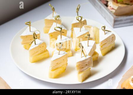 Delicious Canapes of Pineapple and Cheese. An appetizing plate of pineapple pieces and cheese canapes on skewers, perfect for any party table of snack Stock Photo