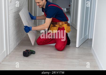 Home improvement, renovation - construction worker tiler is tiling, ceramic tile floor adhesive Stock Photo