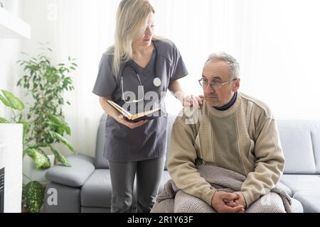 Upset older man listening to supportive speech of pleasant female doctor, head shot close up. Middle aged kind medical specialist old male patient Stock Photo