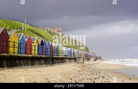 Row of colorful beach huts in Mundesley, Norfolk on overcast day Stock Photo