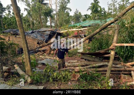 Cox's Bazar, Bangladesh. 15th May, 2023. A man tries to retrieve his belongings after his house was damaged by cyclone Mocha in Cox's Bazar, Bangladesh, on May 15, 2023. Cyclone Mocha, packing winds of up to 200 mph, brought destructive winds and a devastating storm surge particularly in Bangladesh's southeastern Cox's Bazar district and its offshore island. Credit: Str/Xinhua/Alamy Live News Stock Photo