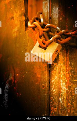 Rusty metal gate closed with padlock - concept image Stock Photo