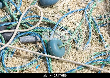 Mixture of colorful fishing nets, floats and ropes. Fisherman material background. Stock Photo