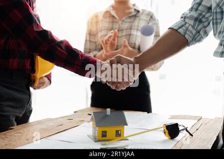 Close up view of engineering team shaking hands after the deal is completed. Team planning for architecture project Stock Photo