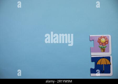 Information puzzle placed on the edge of the blue background. Flowers, umbrellas Stock Photo