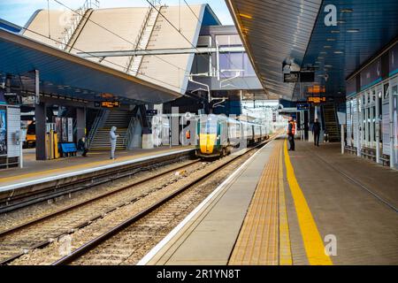 A GWR train arrives at the platform at Reading Railway Station in Berkshire, UK as passengers wait to board the new arrival Stock Photo