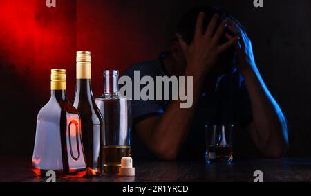 Bottles with alcoholic beverages and the figure of a drunk man Stock Photo