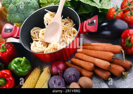 Fresh vegetables and cooking pot on kitchen table Stock Photo