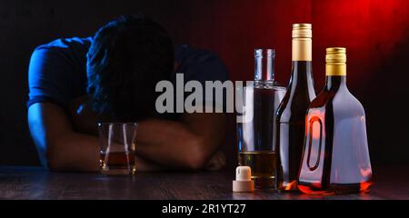 Bottles with alcoholic beverages and the figure of a drunk man Stock Photo