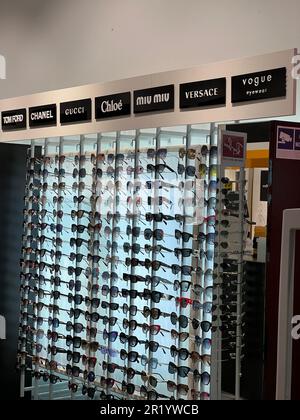 Poland, Warsaw - July 12, 2022: Many stylish sunglasses from popular brands on racks in shopping mall Stock Photo