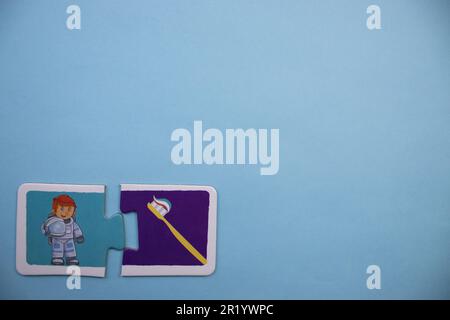 Information puzzle placed on the edge of the blue background. Astronaut, toothbrush Stock Photo