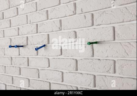 Decorative white bricks with tile leveling system on wall Stock Photo