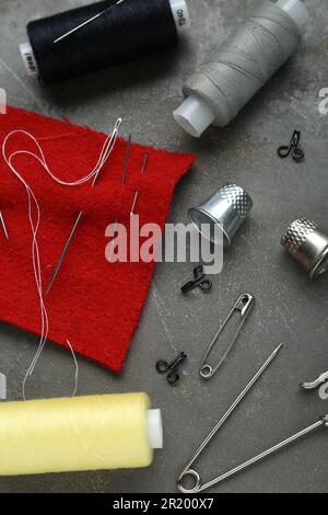 Flat lay composition with thimbles and different sewing tools on grey table Stock Photo