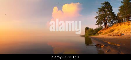 Impressive summer sunrise on the lake with sandy beach and old pine forest. Sunny outdoor scene on the Dnieper river, Ukraine, Europe. Beauty of natur Stock Photo
