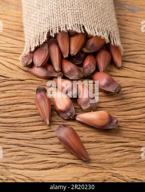 Pinions or pine tree seeds on a bag over wooden table. Stock Photo