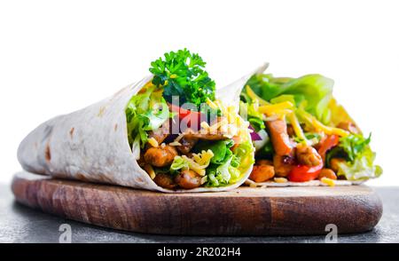 Tortilla with chicken and fresh vegetables isolated on white Stock Photo