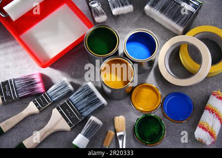 Paint cans and paintbrushes of different size for home decorating purposes Stock Photo