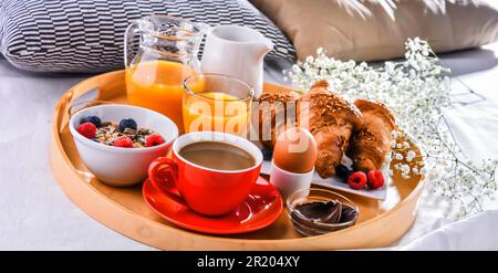 A tray with breakfast on a bed in a hotel room Stock Photo