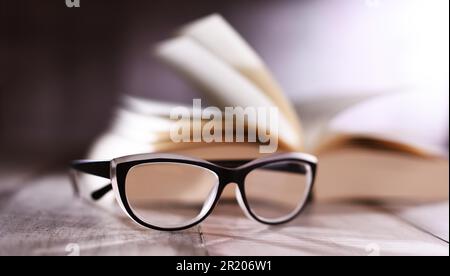 Composition with glasses and open book on the table Stock Photo