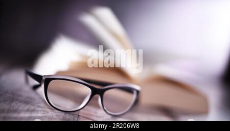 Composition with glasses and open book on the table Stock Photo