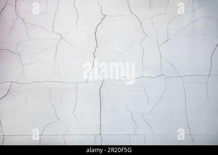 Small cracks on fresh painted plaster on a white wall, non-compliance with technologies in construction Stock Photo